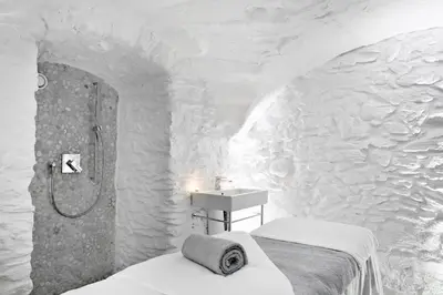 a bathroom with a bed and a shower and a sink at Hotel Mont Blanc Megève in Megève
