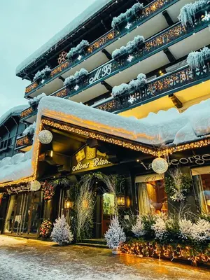 a building with christmas decorations in front of it at Hotel Mont Blanc Megève in Megève