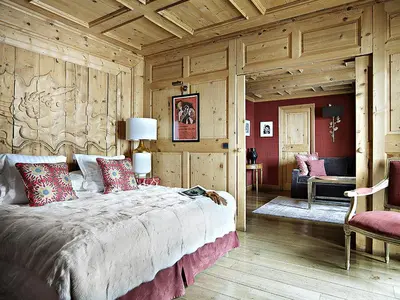 a bedroom with a large bed and wooden walls at Hotel Mont Blanc Megève in Megève