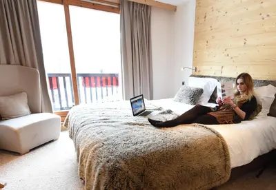 a bedroom with a bed with white sheets and pillows at Park Hotel Suisse & Spa in Chamonix-Mont-Blanc