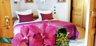 a bedroom with a white bed with red pillows at Park Hotel Suisse & Spa in Chamonix-Mont-Blanc