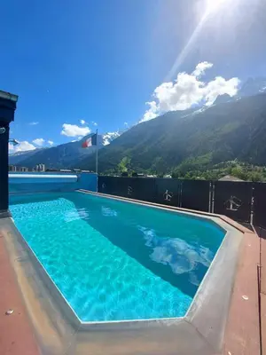 a hot tub on a balcony with mountains in the background at Park Hotel Suisse & Spa in Chamonix-Mont-Blanc