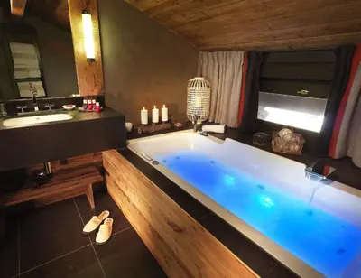 a bathroom with a large tub and a sink at M de Megève in Megève