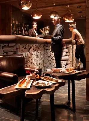 a group of people standing at a bar with food at M de Megève in Megève