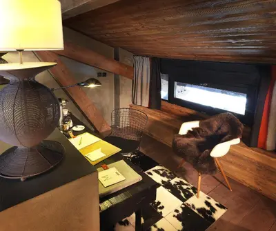 a room with a desk and a lamp on a table at M de Megève in Megève