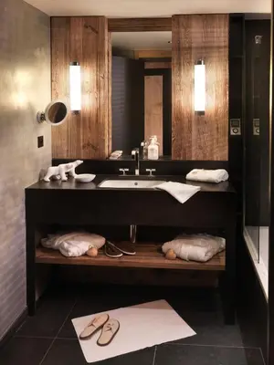 a bathroom with a sink and a mirror and towels at M de Megève in Megève