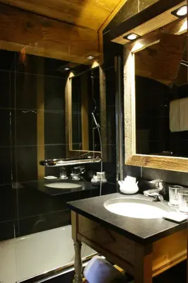 a bathroom with a sink and a mirror and a tub at M de Megève in Megève