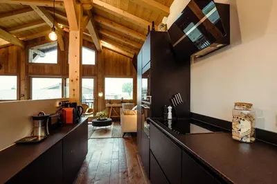 a kitchen with black counter tops and wooden ceilings at Chalet du Rachet Chamonix Mont-Blanc in Les Houches