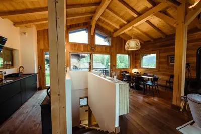 a kitchen and dining room of a log home with wooden ceilings at Chalet du Rachet Chamonix Mont-Blanc in Les Houches