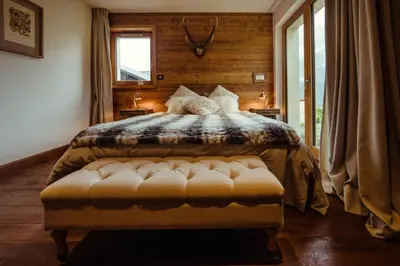 a bedroom with a large bed and a window at Chalet du Rachet Chamonix Mont-Blanc in Les Houches
