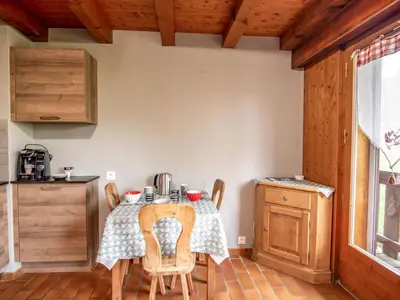a kitchen with a table and a clock on the wall at Studio Les G'rets-10 by Interhome in Saint-Gervais-les-Bains