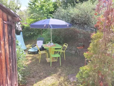 a table and chairs under an umbrella in a yard at Apartment A la Claire Fontaine 1 by Interhome in Mémontel