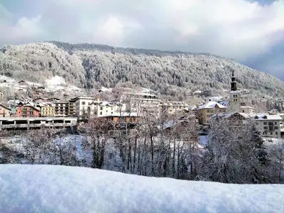 a town covered in snow in front of a mountain at Apartment A la Claire Fontaine 2 by Interhome in Mémontel