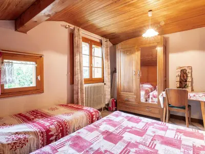 a bedroom with two beds and a table and a window at Apartment A la Claire Fontaine 2 by Interhome in Mémontel