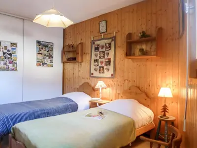 two beds in a room with wooden walls at Apartment L'Espace Montagne-15 by Interhome in Chamonix-Mont-Blanc