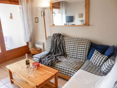 a living room with a couch and a table with wine glasses at Apartment L'Espace Montagne-15 by Interhome in Chamonix-Mont-Blanc