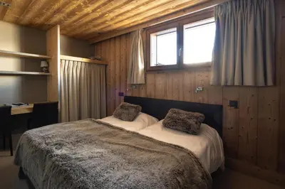 a bedroom with a large bed with two pillows on it at Chalet-Hôtel Les Rhodos in Cordon