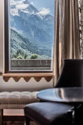 a living room with a blue couch and a tv at Chalet-Hôtel Hermitage in Chamonix-Mont-Blanc