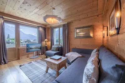 a table with drinks on top of a wooden table with mountains at Chalet-Hôtel Hermitage in Chamonix-Mont-Blanc