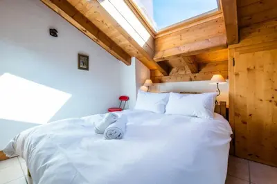 a bedroom with a large white bed with a skylight at Glacier - Les Amethystes in Les Houches