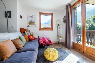 a living room with a blue couch and a window at Glacier - Les Amethystes in Les Houches