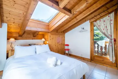 a bedroom with a large white bed in a wooden ceiling at Glacier - Les Amethystes in Les Houches