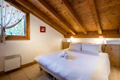 a bedroom with a white bed in a room with a window at Glacier - Les Amethystes in Les Houches