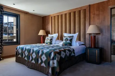 a bedroom with a large bed and two lamps at Lodge Park in Megève