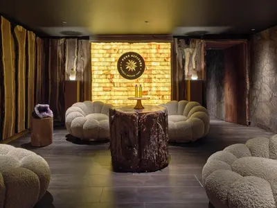 a lobby with a table and chairs and a clock at Lodge Park in Megève