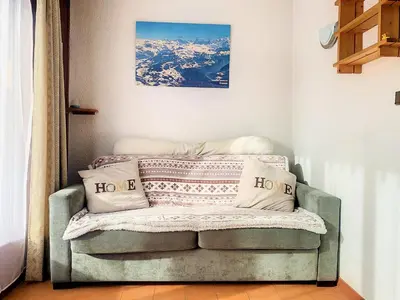 a chair with pillows on it in a room at Studio 4 Pers (AM113) in Les Carroz d'Araches