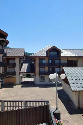 a large building with a parking lot and a street light at Studio 4 Pers (AM113) in Les Carroz d'Araches