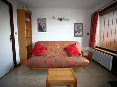 a room with a couch with red pillows on it at AG005 - Studio coin montagne proche pistes in Les Carroz d'Araches