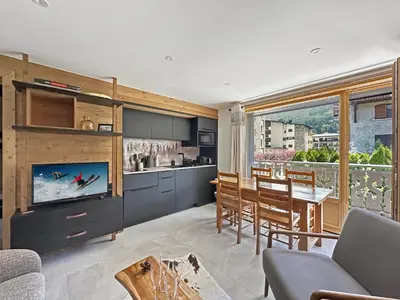a kitchen and dining room with a tv and a table at CA111 - Studio 4 pers centre des Carroz in Les Carroz d'Araches