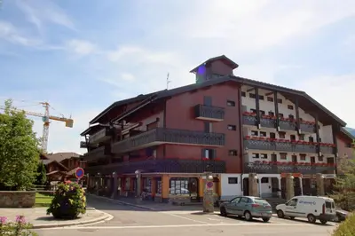 a large red building with cars parked in front of it at CA111 - Studio 4 pers centre des Carroz in Les Carroz d'Araches