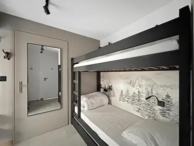 a bedroom with two bunk beds and a bathroom at CA111 - Studio 4 pers centre des Carroz in Les Carroz d'Araches