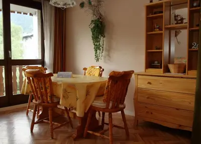 a dining room with a table with chairs and a dresser at CL349 - Studio 4 Pers centre des Carroz in Les Carroz d'Araches
