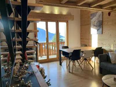 a living room with a table and chairs and a large window at CX116 - Duplex 6 pers Pied de pistes in Les Carroz d'Araches