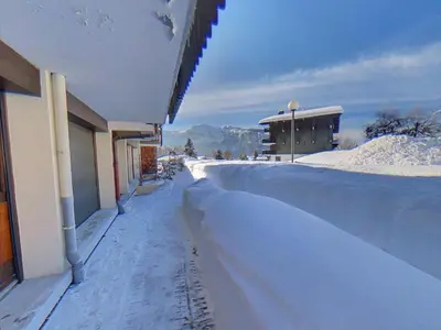a snow covered sidewalk next to a building at EA115 - 2 Pièces 6 Pers proche centre des Carroz in Les Carroz d'Araches