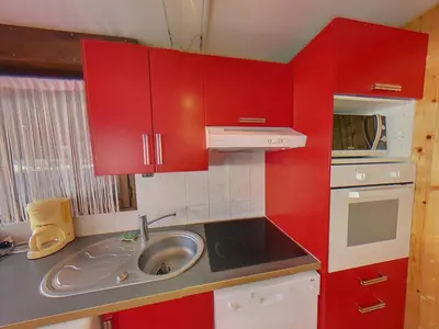 a small kitchen with red cabinets and a sink at EA115 - 2 Pièces 6 Pers proche centre des Carroz in Les Carroz d'Araches