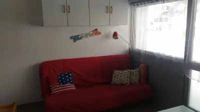 a red couch with two pillows on it in a room at EA115 - 2 Pièces 6 Pers proche centre des Carroz in Les Carroz d'Araches
