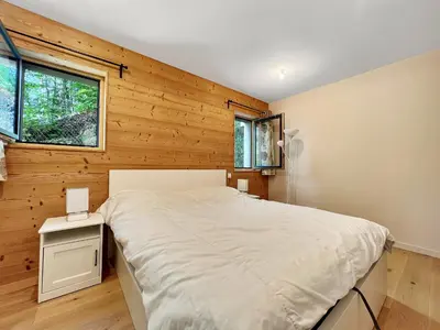 a bedroom with a wooden wall with a bed and a window at GCF211 appartement 6 pers pied de piste in Les Carroz d'Araches
