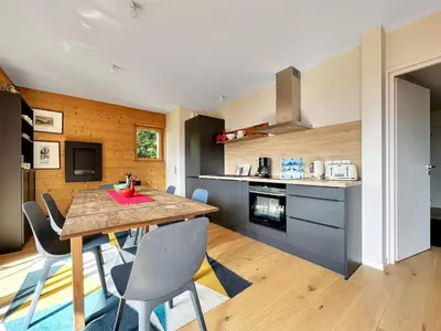 a kitchen and dining room with a wooden table and chairs at GCF211 appartement 6 pers pied de piste in Les Carroz d'Araches