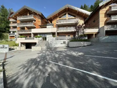 a parking lot in front of a building at GCF211 appartement 6 pers pied de piste in Les Carroz d'Araches