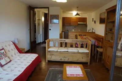 a living room with a couch and a kitchen at GR007 - 2 Pièces 5/6 pers centre Carroz in Les Carroz d'Araches