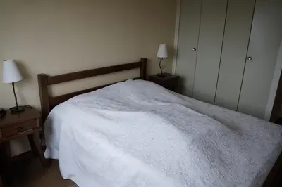 a bedroom with a white bed and two night stands at GR007 - 2 Pièces 5/6 pers centre Carroz in Les Carroz d'Araches
