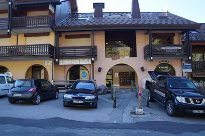 two cars parked in a parking lot in front of a building at NAN01 - Studio 4 Pers Télécabine in Les Carroz d'Araches