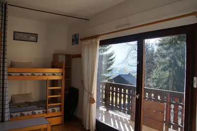a bedroom with a bunk bed and a large window at NAN01 - Studio 4 Pers Télécabine in Les Carroz d'Araches