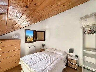 a bedroom with a bed and a wooden ceiling at OB222 - 2 pièces Mezzanine 6 pers pieds de pistes in Les Carroz d'Araches