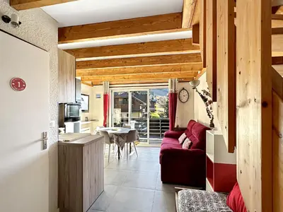 a living room with a red couch and a table at OB222 - 2 pièces Mezzanine 6 pers pieds de pistes in Les Carroz d'Araches