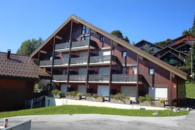 an apartment building with balconies and a parking lot at OB222 - 2 pièces Mezzanine 6 pers pieds de pistes in Les Carroz d'Araches